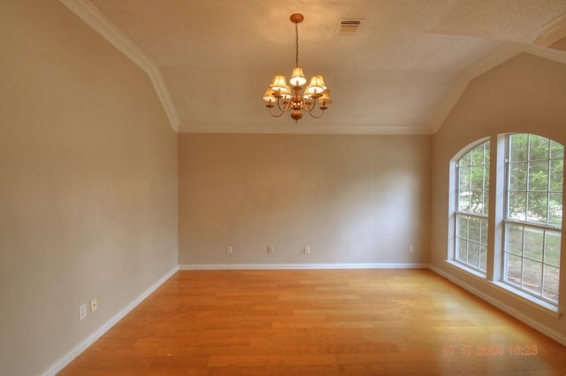 spare room with light wood finished floors, visible vents, an inviting chandelier, ornamental molding, and baseboards