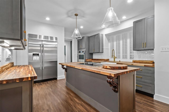 kitchen with wood counters, stainless steel appliances, dark wood-style floors, gray cabinets, and recessed lighting