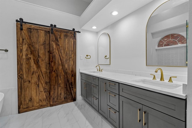 full bath with double vanity, marble finish floor, a sink, and recessed lighting