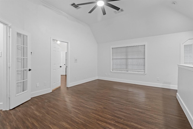 interior space featuring dark wood-style floors, vaulted ceiling, and visible vents