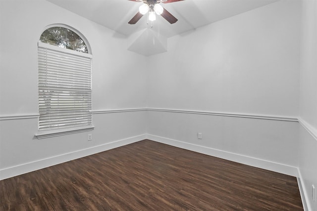 empty room featuring ceiling fan, baseboards, and dark wood-style flooring