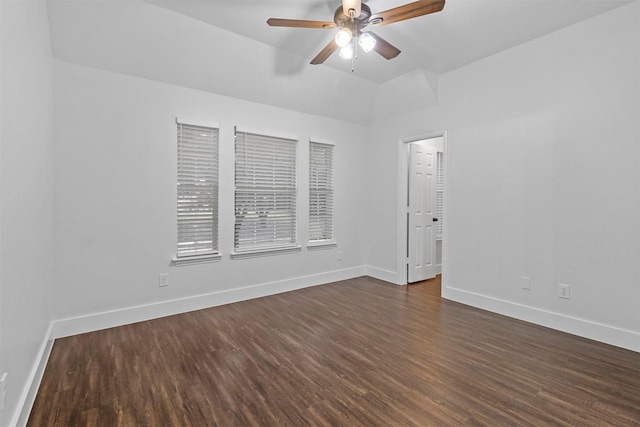 unfurnished room featuring ceiling fan, dark wood-type flooring, lofted ceiling, and baseboards