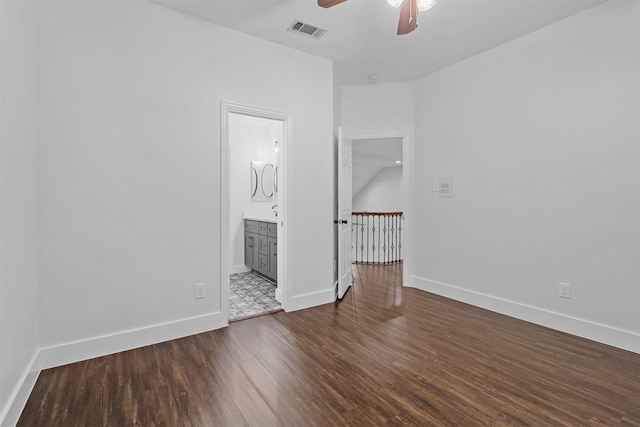 unfurnished room with dark wood-style floors, baseboards, visible vents, and a ceiling fan