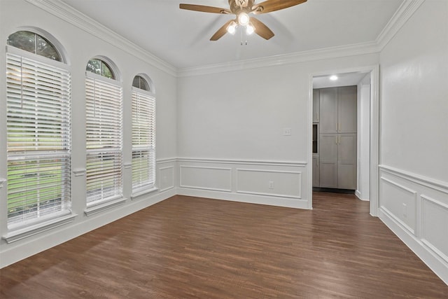 unfurnished room featuring dark wood-type flooring, ceiling fan, a decorative wall, and ornamental molding