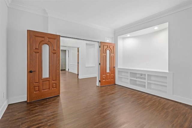 empty room featuring crown molding, dark wood-style floors, baseboards, recessed lighting, and built in shelves