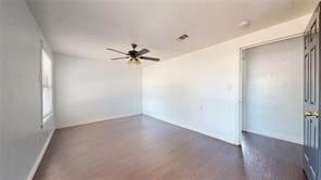 unfurnished room featuring ceiling fan and dark wood-type flooring