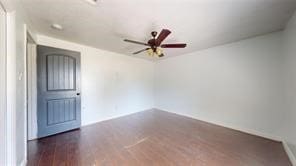 spare room featuring dark wood-style floors and a ceiling fan