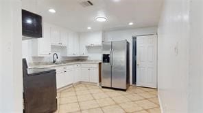 kitchen featuring recessed lighting, white cabinets, a sink, and stainless steel refrigerator with ice dispenser