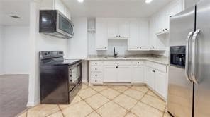 kitchen with white cabinetry, appliances with stainless steel finishes, light countertops, and a sink