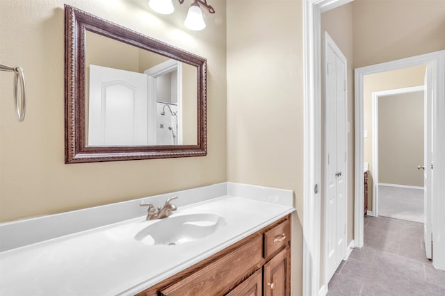 bathroom with vanity, baseboards, and tile patterned floors
