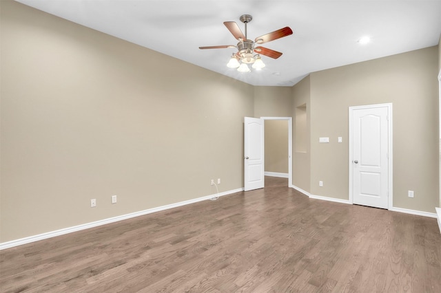 unfurnished bedroom with ceiling fan, wood finished floors, and baseboards