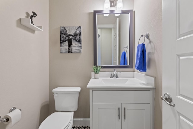 bathroom with baseboards, vanity, and toilet