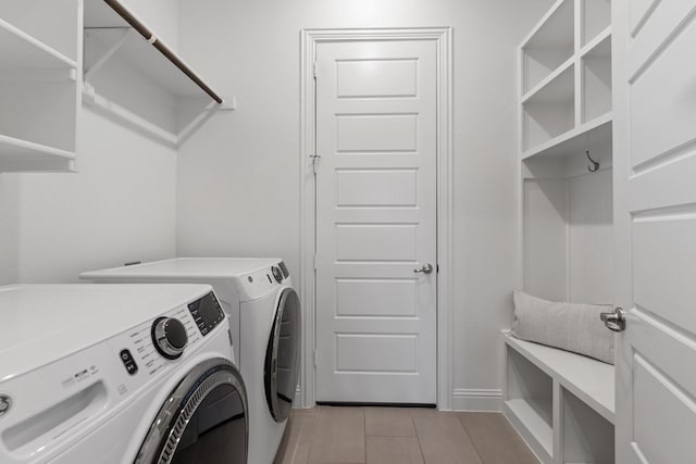 washroom with laundry area, light tile patterned flooring, and washing machine and clothes dryer