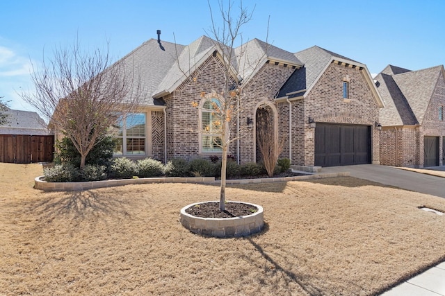 view of front of house featuring concrete driveway, brick siding, an attached garage, and a shingled roof