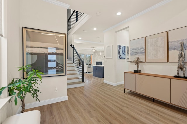 foyer with baseboards, stairs, crown molding, light wood-type flooring, and recessed lighting