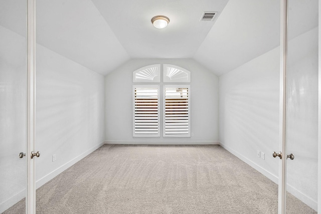 additional living space with vaulted ceiling, visible vents, baseboards, and carpet floors