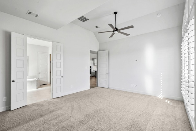 unfurnished bedroom with carpet flooring, baseboards, visible vents, and vaulted ceiling