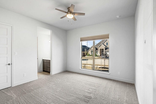 empty room with light colored carpet, baseboards, and ceiling fan