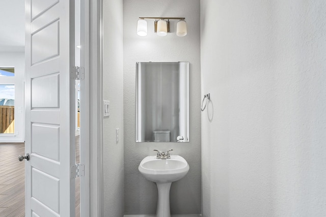 bathroom featuring wood finished floors and a textured wall