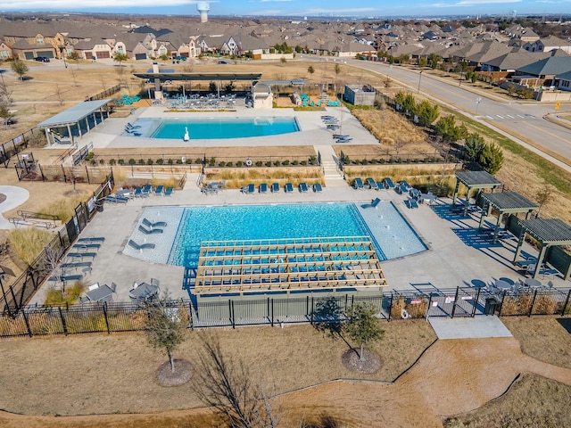 view of swimming pool featuring a residential view and fence