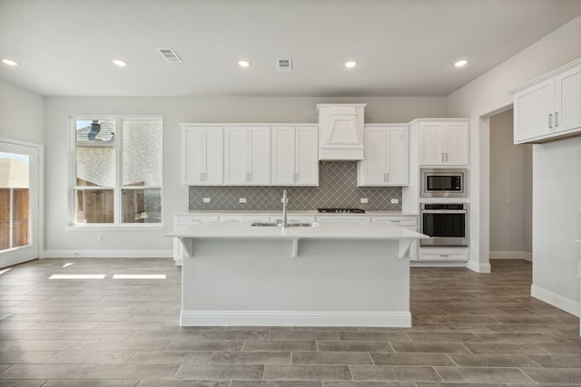 kitchen with a sink, visible vents, light countertops, appliances with stainless steel finishes, and tasteful backsplash