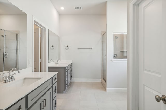 full bathroom featuring tile patterned flooring, two vanities, a sink, visible vents, and a shower stall