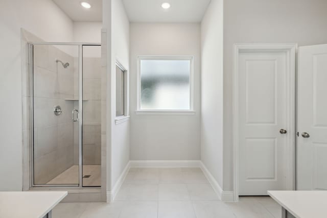 full bath featuring tile patterned floors, a shower stall, and baseboards