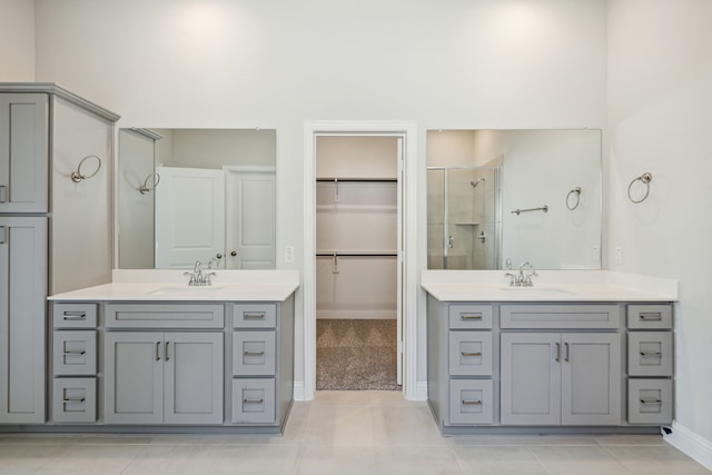 bathroom featuring tile patterned floors, two vanities, a sink, and a shower stall