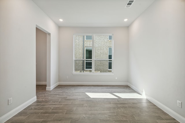 empty room featuring recessed lighting, wood finished floors, visible vents, and baseboards