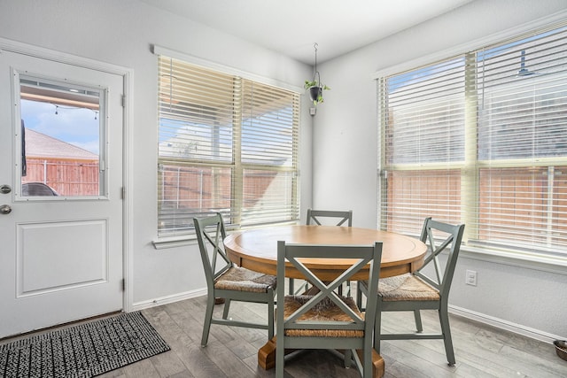 dining space with baseboards and wood finished floors