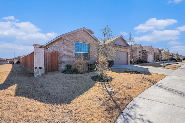 single story home with a garage, fence, concrete driveway, and brick siding