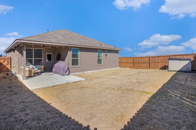 back of property featuring a ceiling fan, a patio area, a fenced backyard, and a lawn