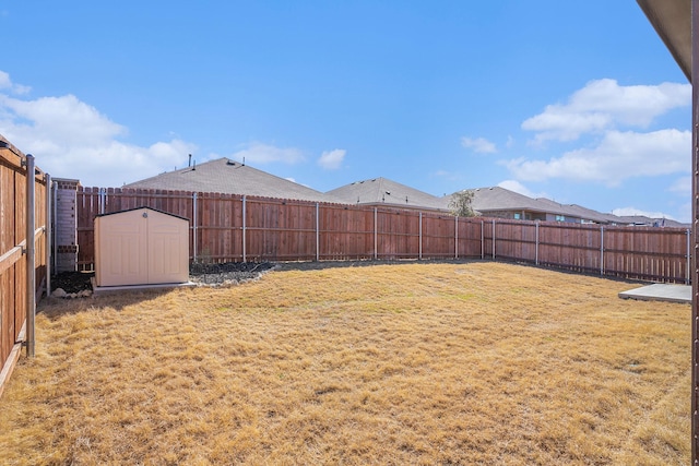 view of yard featuring an outbuilding, a storage shed, and a fenced backyard