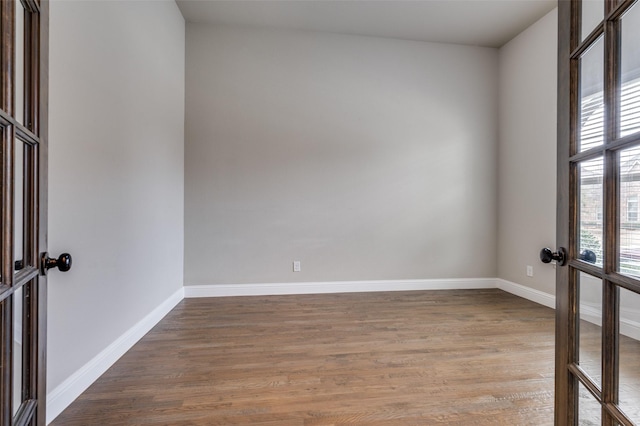 unfurnished room with light wood-style flooring, baseboards, and french doors