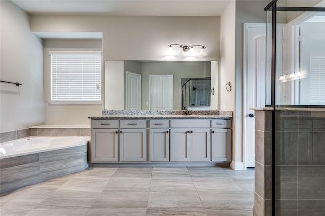 full bath featuring a stall shower, a garden tub, and vanity