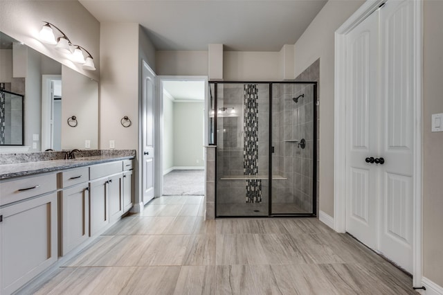 full bath with a shower stall, baseboards, and vanity