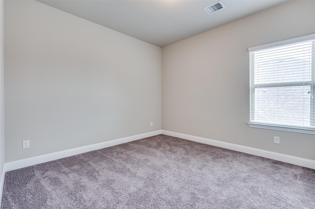 empty room with baseboards, visible vents, and carpet flooring