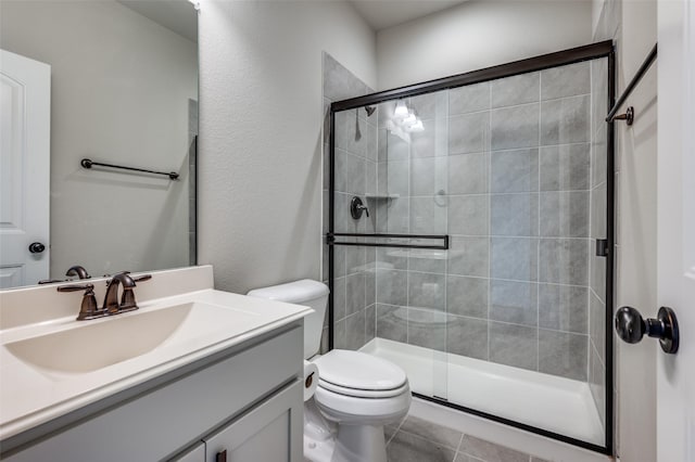 bathroom featuring toilet, a stall shower, tile patterned floors, and vanity