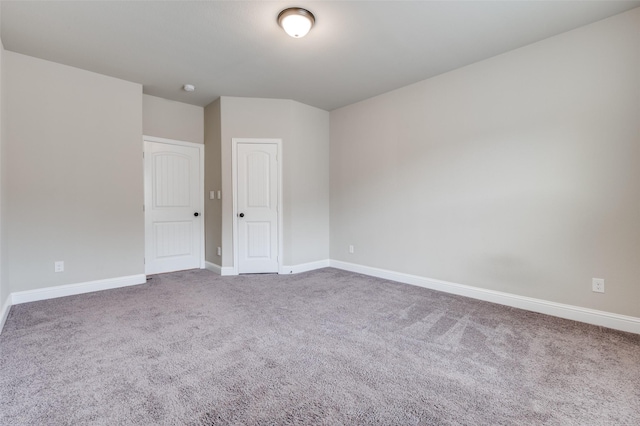 spare room featuring baseboards and carpet flooring