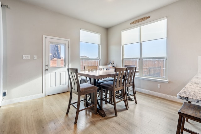 dining room featuring light wood-style flooring and baseboards