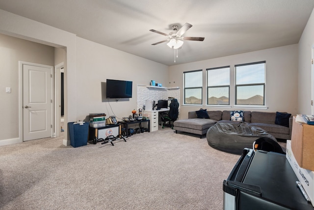 carpeted living area featuring a ceiling fan and baseboards