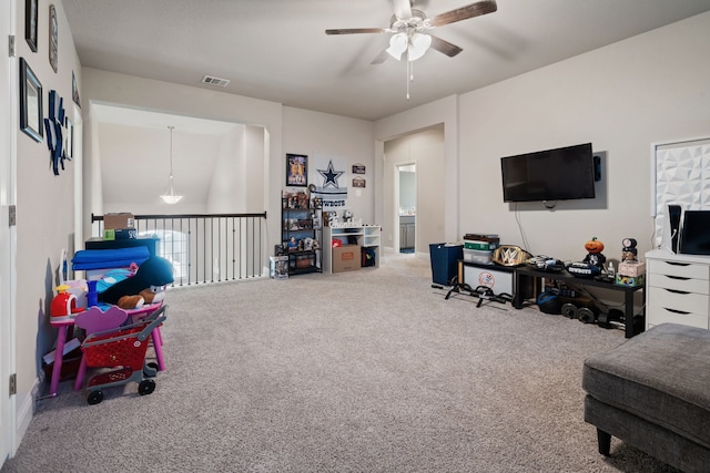 interior space with a ceiling fan, visible vents, and carpet flooring