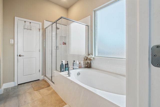 bathroom with a stall shower and a garden tub