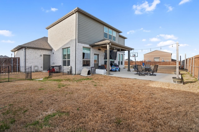 rear view of house with brick siding, a fenced backyard, a yard, and a patio