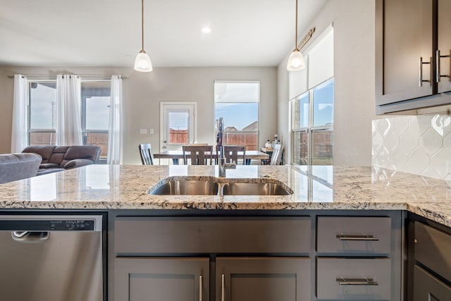 kitchen with a sink, backsplash, gray cabinets, and stainless steel dishwasher