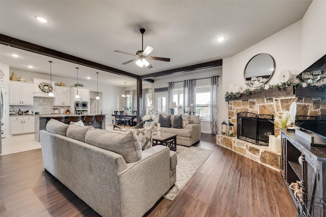 1016 Northern Oaks Ct, Springtown, TX 76082 - living area featuring a stone fireplace, ceiling fan, wood finished floors, recessed lighting, and beamed ceiling