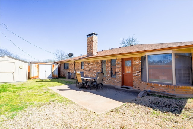 back of property featuring a storage unit, a chimney, a patio area, and brick siding