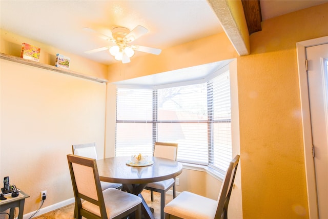 dining area featuring ceiling fan and baseboards