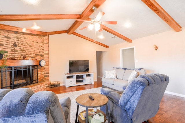 living room with visible vents, lofted ceiling with beams, a ceiling fan, a brick fireplace, and wood finished floors