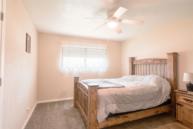 carpeted bedroom with ceiling fan and baseboards